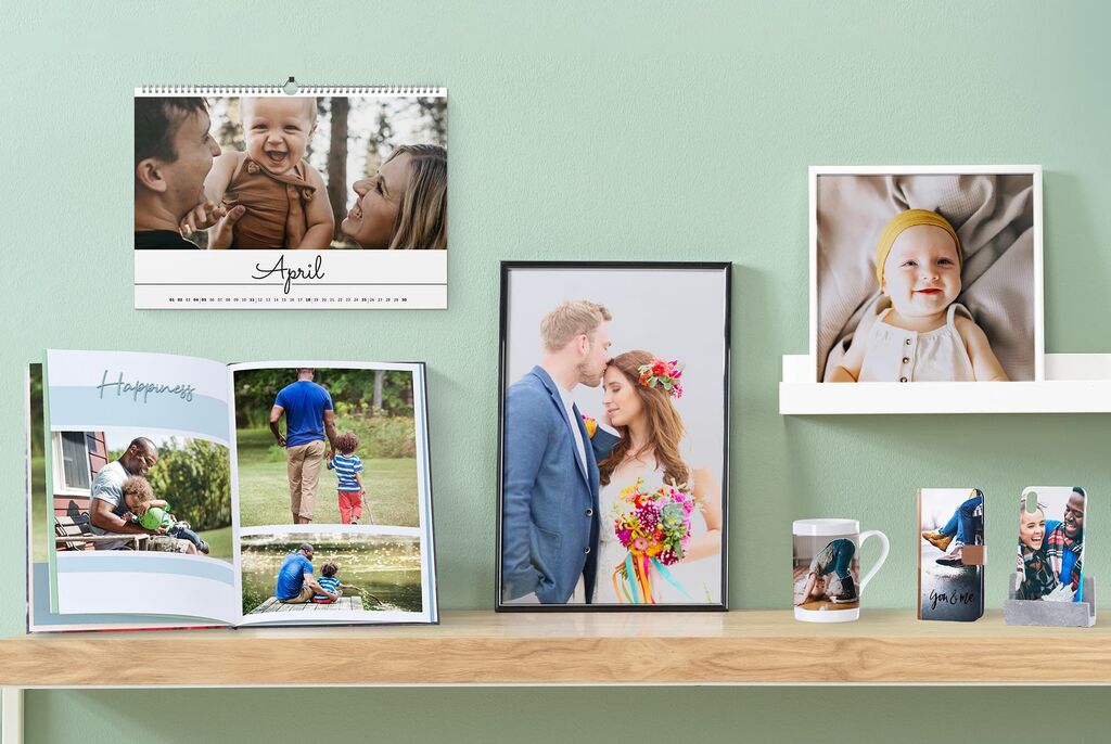 Et stilig bord med ulike fotoprodukter: en kalender, et rammet bilde, et fotobok og en kopp som viser kreative minner