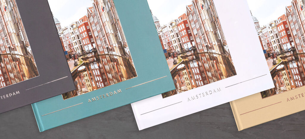Tre forskjellige fargevarianter av en CEWE fotobok viser bygninger i Amsterdam.