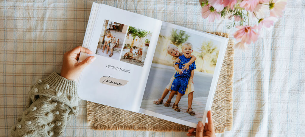 En person blar gjennom en CEWE fotobok med bilder av glade barn.